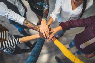 Different People Putting Hands In Stack